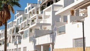 A modern multi-story building with balconies, white walls, and a clear blue sky. - Stylish 2BR Apt | Balcony & Sea Views (Benalmádena)