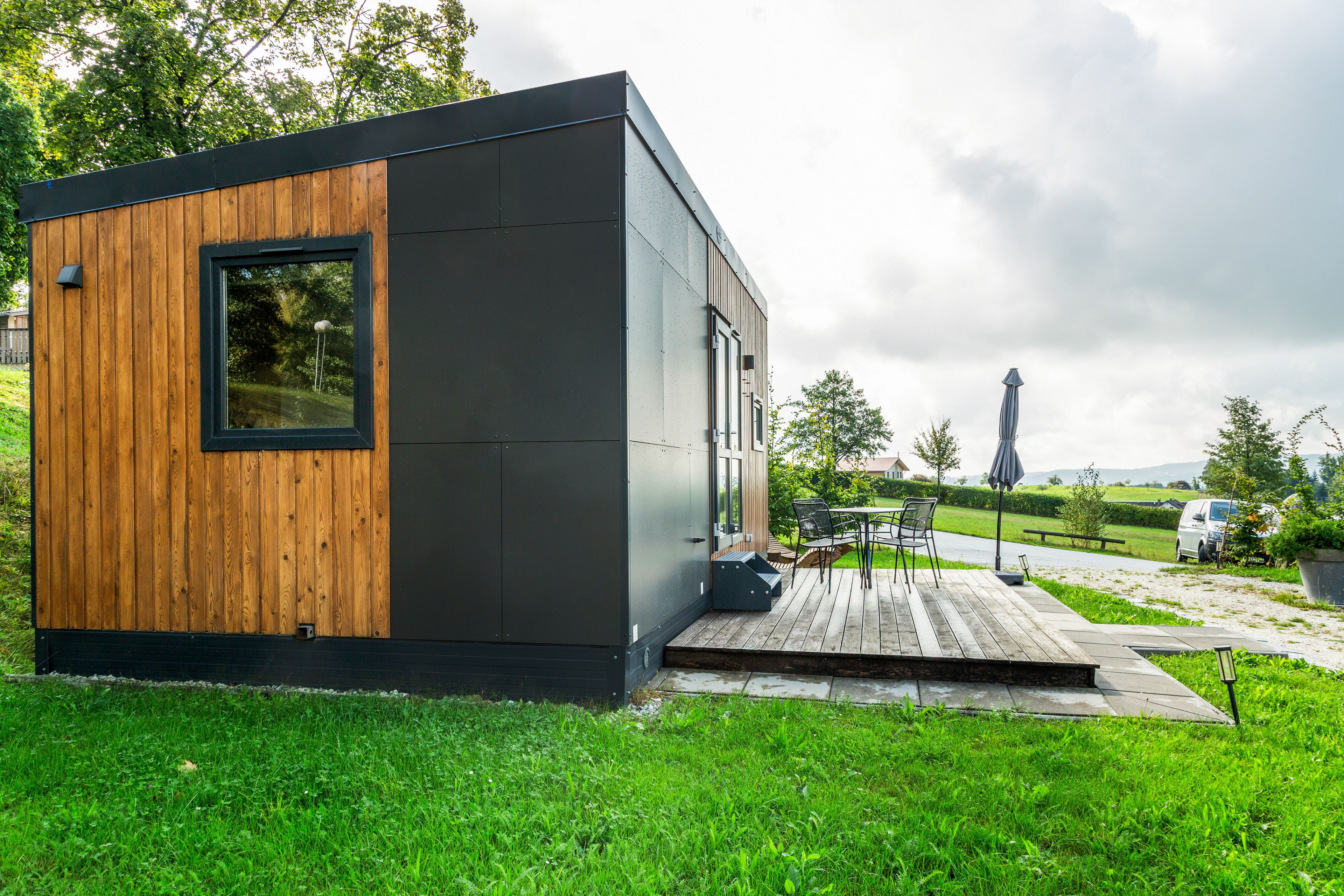 Un bâtiment moderne et compact, doté d’une façade en bois et d’une couleur extérieure noire.