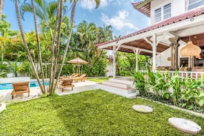 A poolside area with lounge chairs, a covered patio, and a well-maintained lawn. - Villa Berlin - 6BDR huge villa, pool and garden (Kuta)