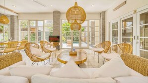 A spacious living area with wicker furniture, a central coffee table, and a ceiling fan.