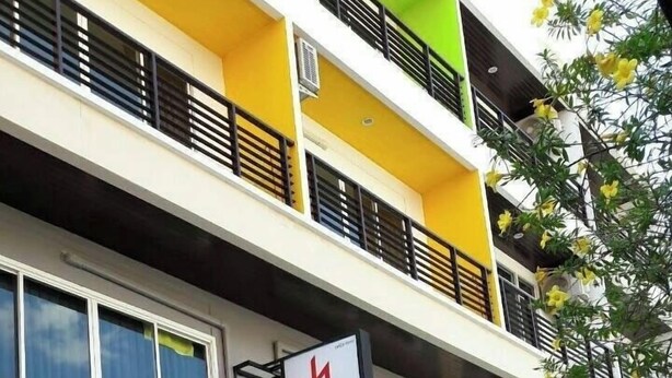 A multi-story building with balconies, air conditioning units, and a storefront with glass doors. - The HideAway Patong Beach (Patong)