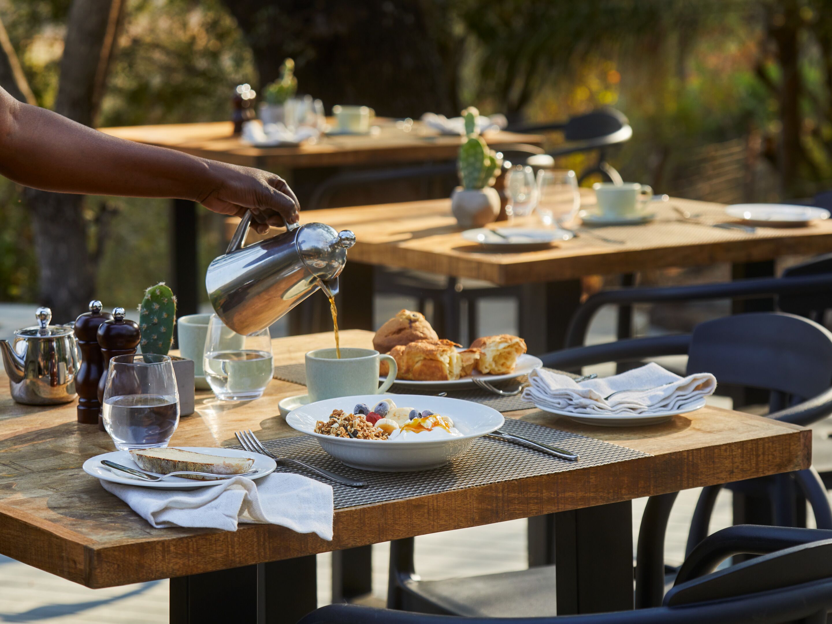 A table set for breakfast with a plate of cereal, a cup of coffee, and a glass of water.