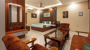 A modern hotel room with a bed, a desk, and two armchairs. - Treebo Sri Anand Residency (Chennai)