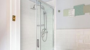 A glass-enclosed shower with a handheld showerhead and a wall-mounted faucet. - Renovated Apartment with Four Brand-New Suites and Two-Level Terrace (Barcelona)