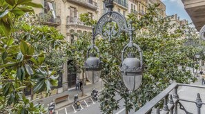 A street with ornate street lamps, a building with balconies, and a pedestrian crossing. - Renovated Apartment with Four Brand-New Suites and Two-Level Terrace (Barcelona)