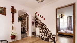 A room with a giraffe-themed wall, a wooden bed, a clock, and a staircase. - Transylvanian Home - Mountain View, BBQ & Pool (Bratca)