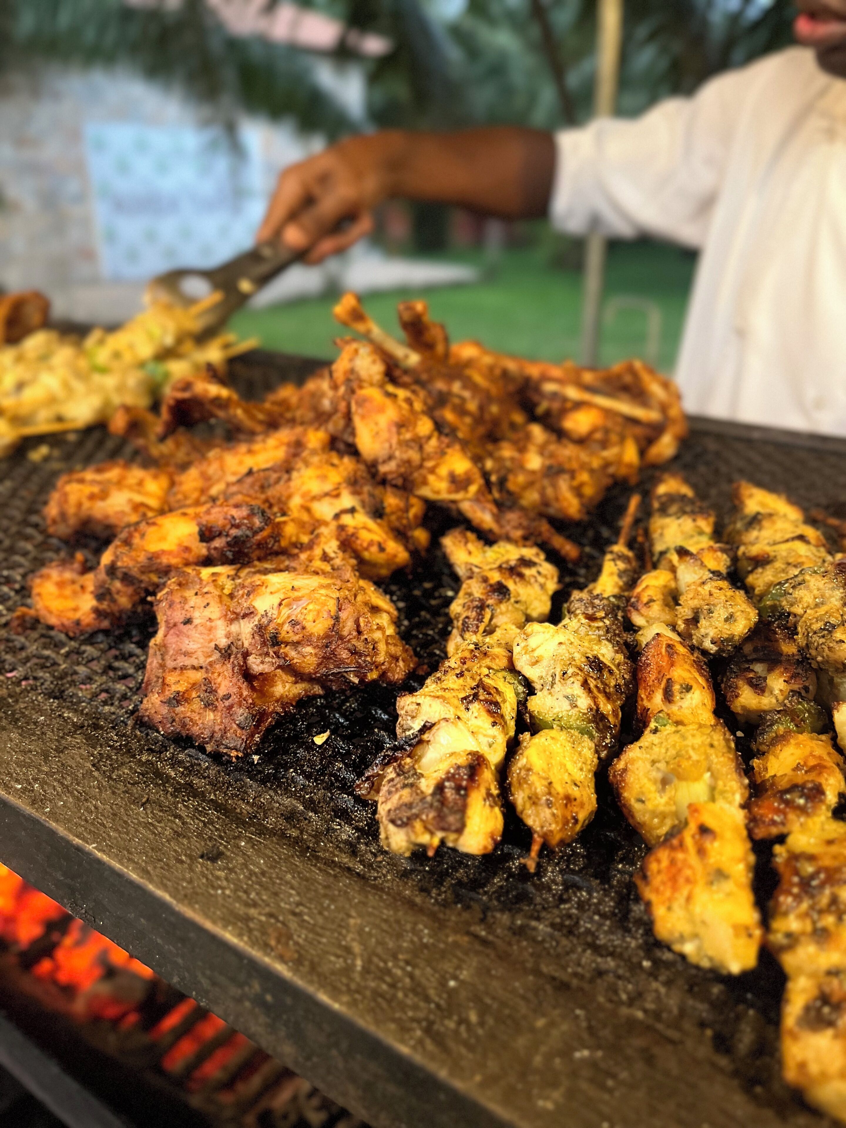 A grill with various skewers of meat being cooked.