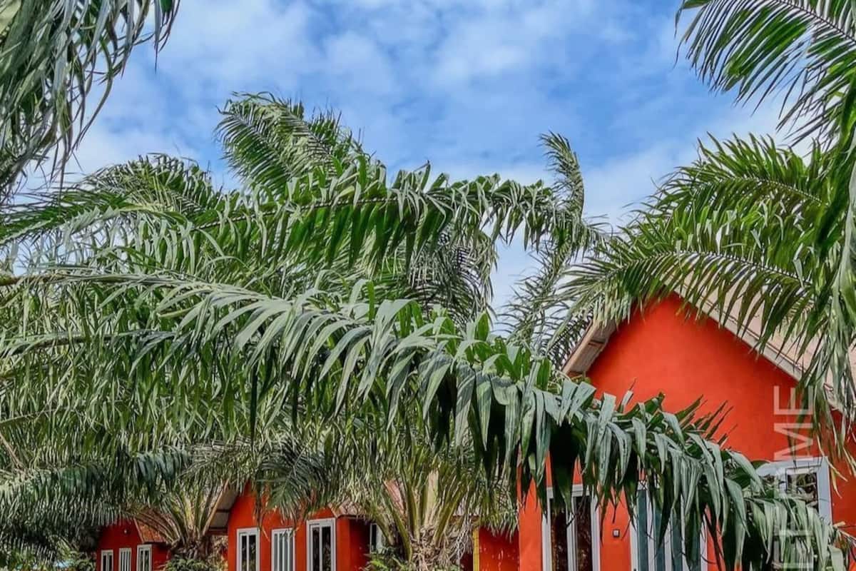 Un edificio rojo con un porche pequeño y una mesa de madera.