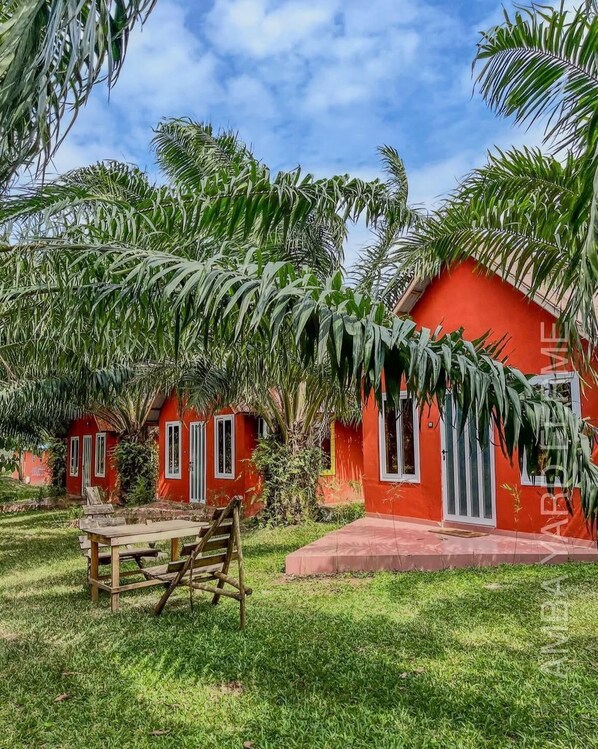 A red building with a small porch and a wooden table.