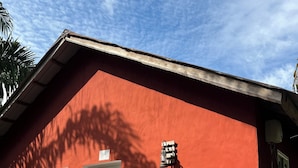 A building with two doors, a red exterior, and a tiled entrance.