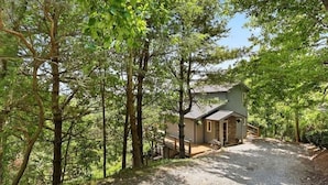 A cabin with a gravel driveway, surrounded by trees. - Your Quiet Mountain Escape (Boone)