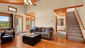 A spacious living room with a wooden floor, a sofa set, a coffee table, and a staircase. - Your Quiet Mountain Escape (Boone)