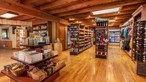 Una tienda espaciosa con pisos de madera y techos altos, que presenta estantes llenos de diversos productos y un área de exhibición central.
