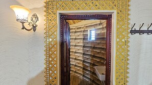 Un vano con un marco de diseño geométrico y una pared de madera con listones horizontales.