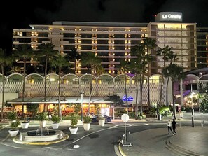 Hotel com vários andares, fachada bem iluminada e entrada com portão.