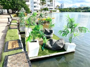 Um cais à beira-mar com plantas em vasos e áreas de estar.
