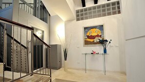 A staircase with a glass table and a framed painting above it. - San Polo Apartment with Balcony  (Venice)
