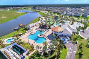 An aerial view of a resort with multiple swimming pools, a dock, and a residential area with houses. - Toy Story Resort Condo – West-Facing Balcony, Waterpark & Pet Friendly (Kissimmee)