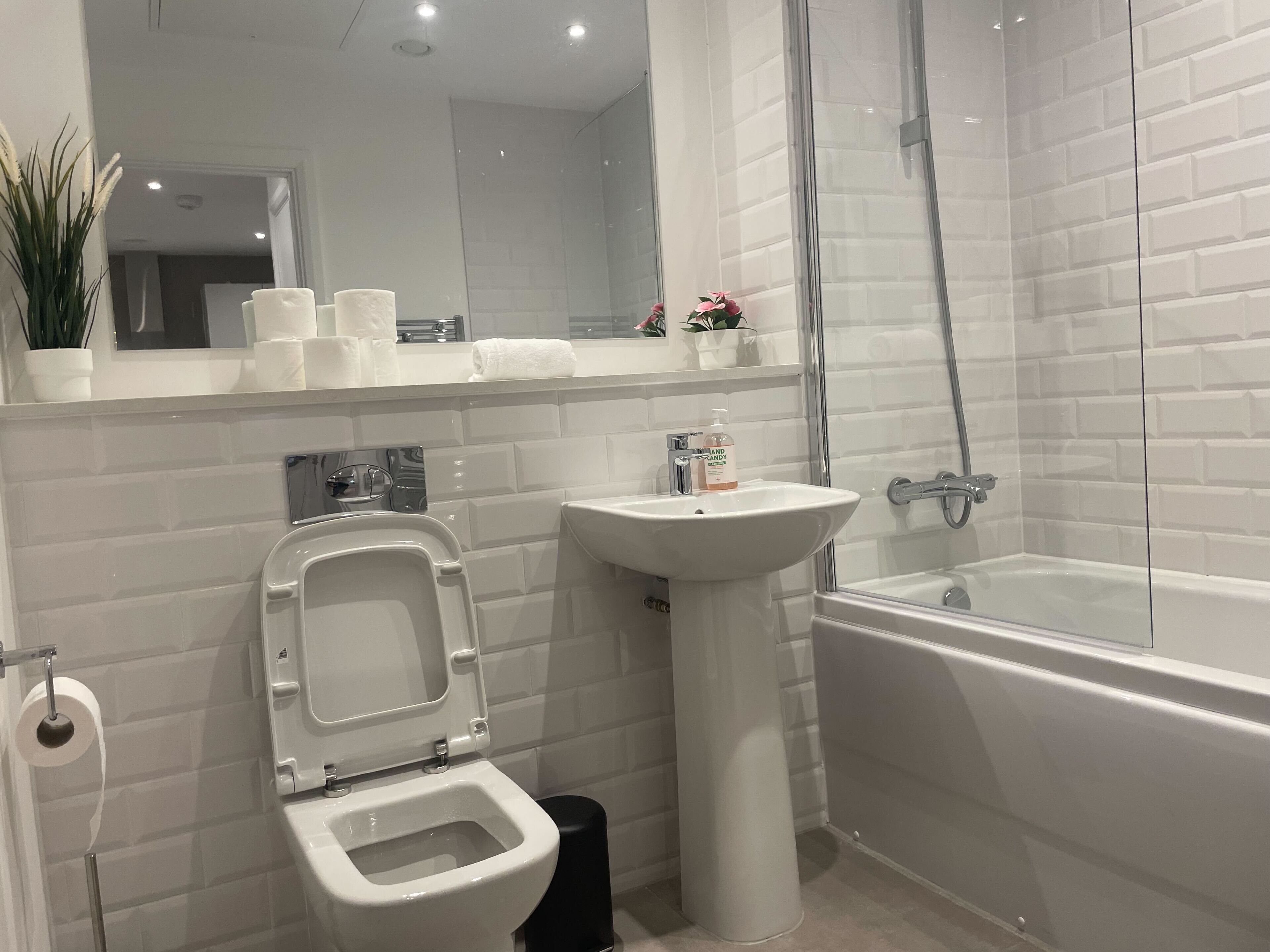 A modern bathroom with a toilet, sink, and bathtub.
