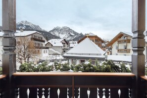 Une chaîne de montagnes enneigées, avec en arrière-plan des bâtiments traditionnels en bois.