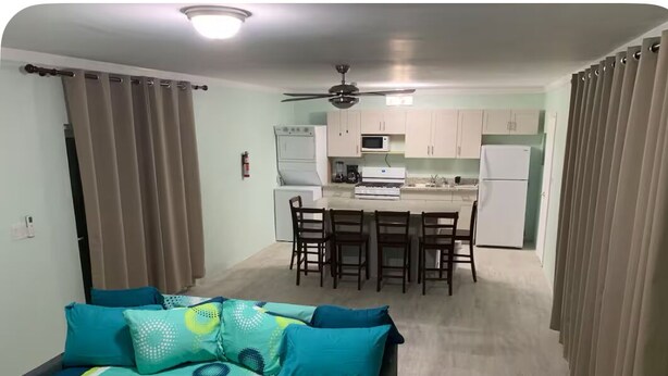 A bedroom with a bed, a kitchenette, and a dining area.
