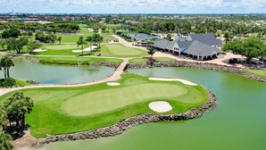 Un campo da golf con numerosi stagni, una club house e vegetazione circostante.