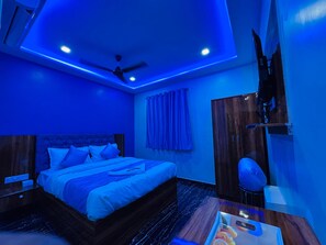 A modern bedroom with a bed, a ceiling fan, and a nightstand. - Welcome Airoli (Navi Mumbai)