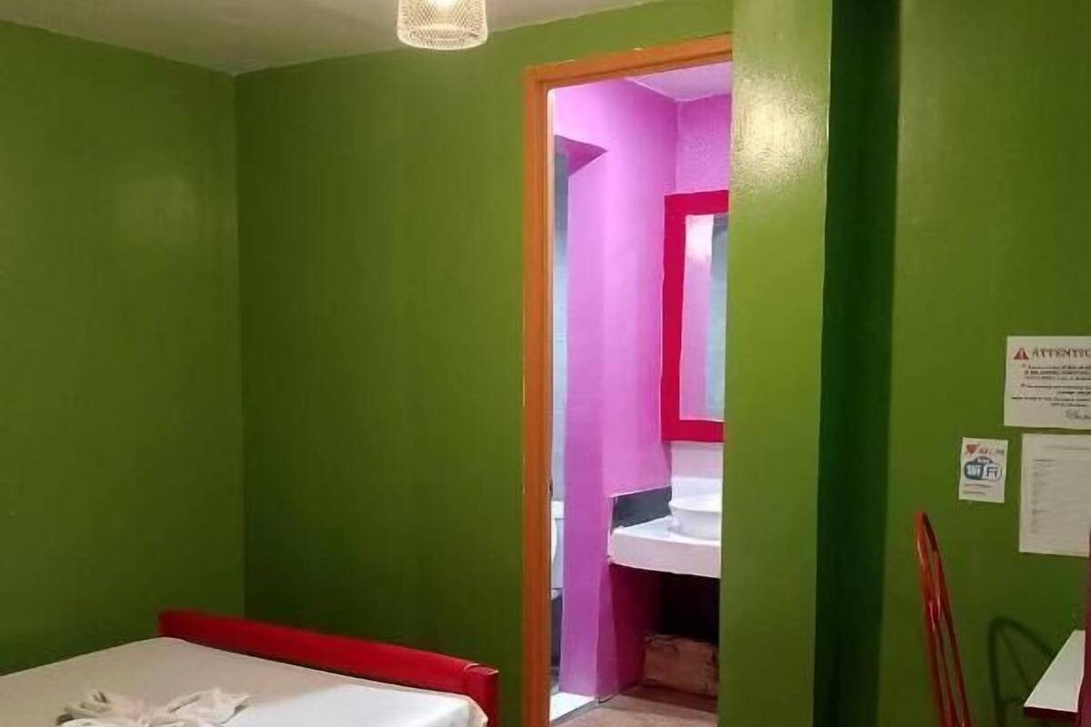 A room with a single bed, a chair, and a small table.