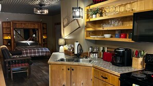 A compact kitchen with wooden cabinets, a built-in microwave, and a stove.