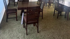A tented dining area with tables and chairs, large windows, and a view of greenery outside. - Riyasat Panthera (Bali)