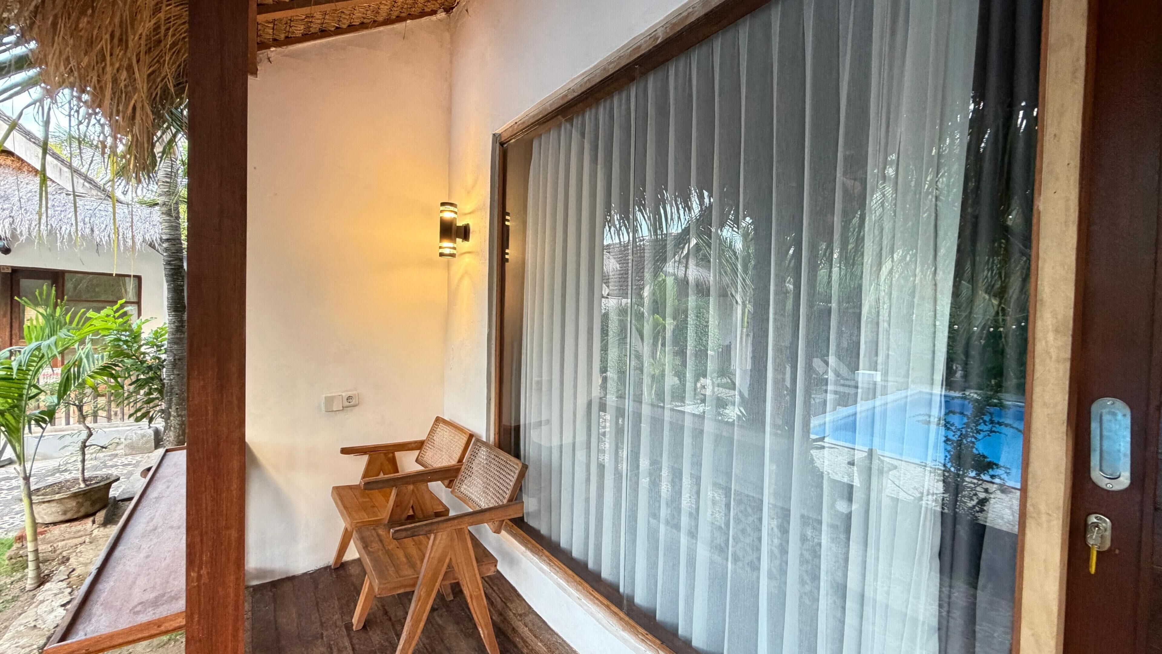 A room with a sliding glass door, a small wooden table, and a chair.