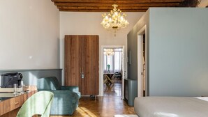 Un dormitorio moderno con techo de madera, una cama grande, un escritorio con silla y un sofá verde.