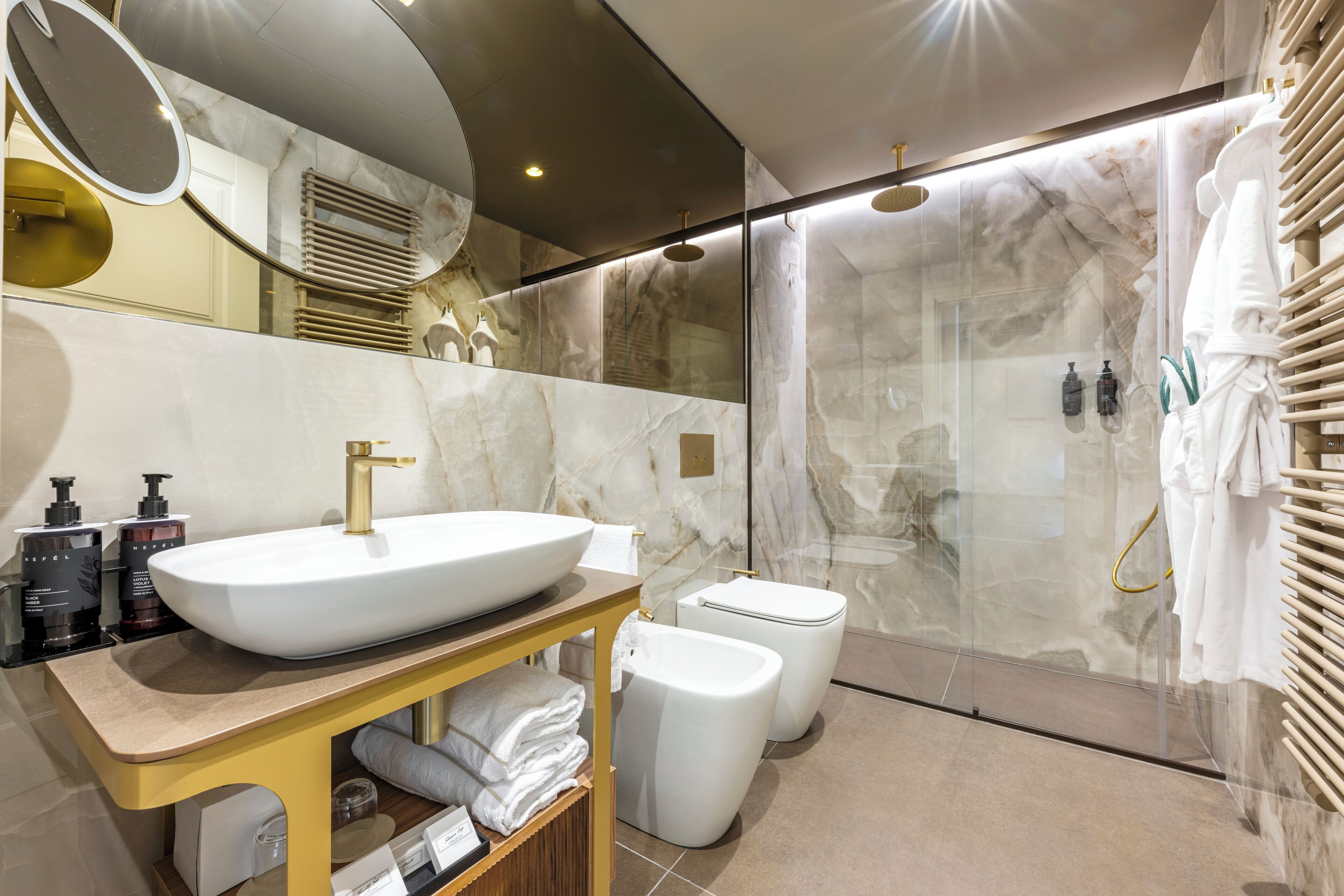 Une salle de bain moderne dotée d’un grand lavabo, de toilettes et d’un espace douche.