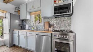 Una cocina moderna con electrodomésticos de acero inoxidable, lavavajillas y cocina a gas.