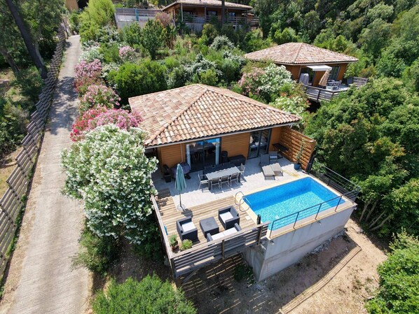 Une villa avec piscine, un espace salon extérieur et un jardin.