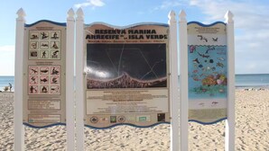 A beach sign with information about marine reserve activities and prohibited actions.