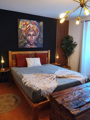 A bedroom with a bed, a wooden headboard, a wall painting, a plant, and a hanging light fixture. - Room 'Lagoa' with Sea View, Private Terrace and Wi-Fi (Lagoa)