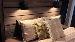 A bed with a wooden headboard, two pillows, and a bedside lamp. - ATL Movie House, Theater Room, Sleeps9, Near Downtown (Atlanta)