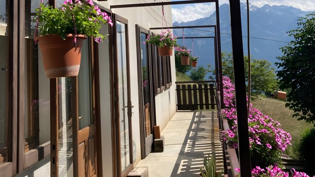 A balcony with hanging flower pots, a wooden railing, and a view of mountains. - Becca D'Aver Apartment with Mountain View, Shared Garden, and Wi-Fi (Semon)