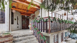 A wooden staircase leading to a house with a wooden railing decorated with greenery and red ornaments. - Becca D'Aver Apartment with Mountain View, Shared Garden, and Wi-Fi (Semon)