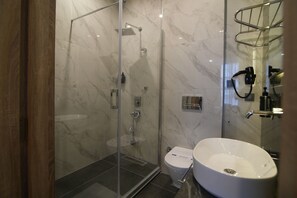 A modern bathroom with a glass-enclosed shower, a white sink, and a toilet. - Kent Room Hotel (Kapaklı)