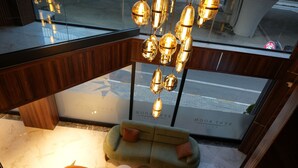 A modern interior with a green sofa, a round table, and hanging pendant lights. - Kent Room Hotel (Kapaklı)