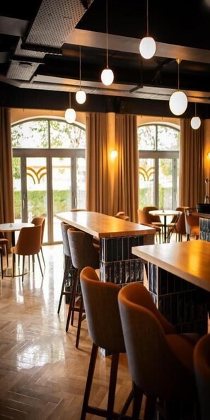 A restaurant with high tables, bar stools, and hanging pendant lights. - The Village Hotel Douglas (Douglas)