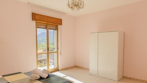 Una camera da letto con un letto, un armadio, una finestra con vista e un lampadario.