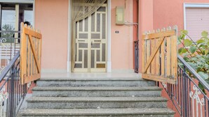Un edificio con una scala in legno che conduce a una porta con motivi a griglia.