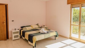 Una camera da letto con un letto, comodini, un lampadario e vista dalla finestra.