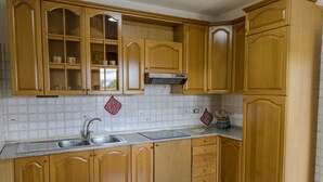 Una cucina con mobili in legno, un lavello in acciaio inossidabile e uno schienale piastrellato.