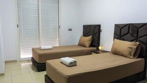 Une chambre d’hôtel avec deux lits, chacun doté d’une t ête de lit et d’oreillers.