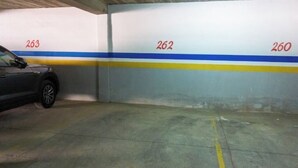 Un parking souterrain avec des places de stationnement numérotées, et une voiture garée sur la place numéro 263.