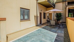 A courtyard with a tiled floor, a seating area with a table and chairs, and a potted plant. - The Orchid - Francavilla al Mare (Francavilla al Mare)